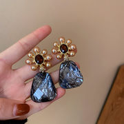 シルバーの針とダイヤモンドの真珠の花のイヤリングが付いた女性の個性のイヤリング